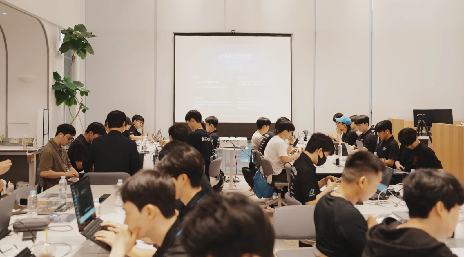 AX인재전쟁 현장에서 참가자들이 노트북으로 과제를 푸는 모습